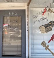 The phrases "FUCK TERFS" and "TRANS WOMEN ARE WOMEN" written on the door and window